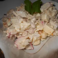 Pyszna sałatka surimi z ryżem, jajkiem i warzywami, udekorowana natką pietruszki.