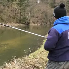 Chłopak łowi ryby na spławik nad rzeką. Pokazuje, jak łowić duże ryby na spławik.