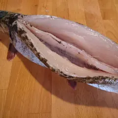 Oczyszczony szczupak na desce, gotowy do dalszej obróbki. Tak przygotowuje się rybę do smażenia lub pieczenia.
