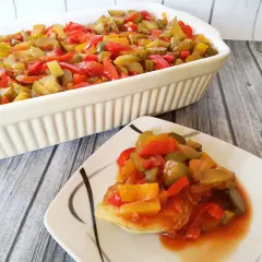 Pyszna ryba na śniadanie z warzywami w sosie. Danie podane w naczyniu żaroodpornym i na talerzu.