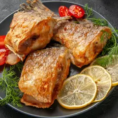Złocisty karp pieczony, podany z cytryną, pomidorkami i koperkiem. Idealny sposób, jak przyprawić karpia do pieczenia, by był pyszny.