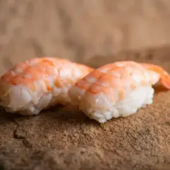 Dwa nigiri z krewetkami na kamiennym tle. Idealne, gdy zastanawiasz się, jak przygotować krewetki do sushi.