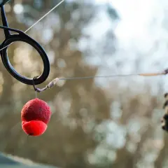 Zbliżenie na haczyk z przynętą i ciężarek, pokazujące różne rodzaje przyponów karpiowych.