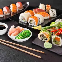 Piękne składniki sushi: nigiri z łososiem i tuńczykiem, rolki z awokado i ogórkiem, sos sojowy, imbir i sałatka wakame.