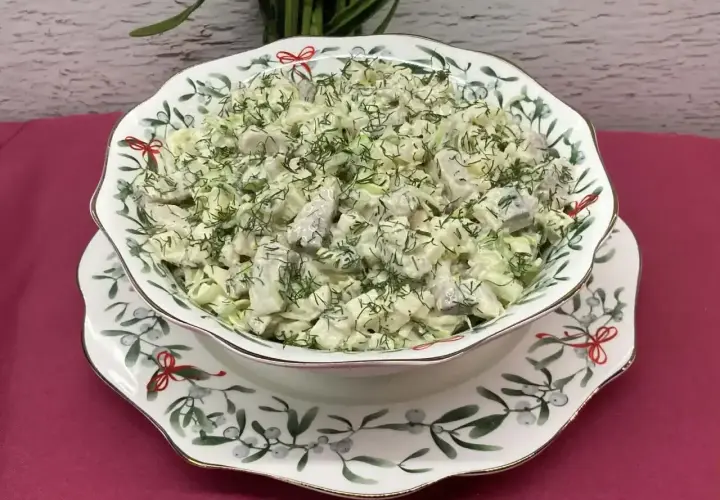 Pyszna sałatka ze śledzi marynowanych z jajkiem, udekorowana świeżym koperkiem, podana w ozdobnej misie.