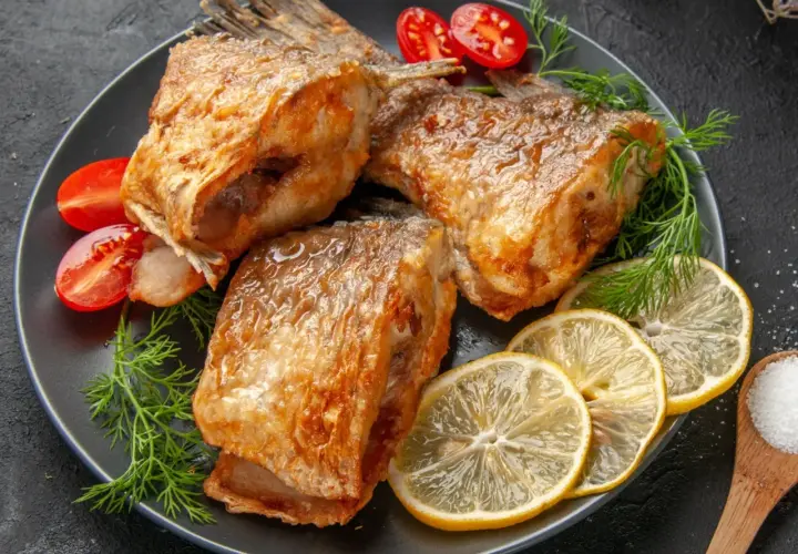 Złocisty karp pieczony, podany z cytryną, pomidorkami i koperkiem. Idealny sposób, jak przyprawić karpia do pieczenia, by był pyszny.