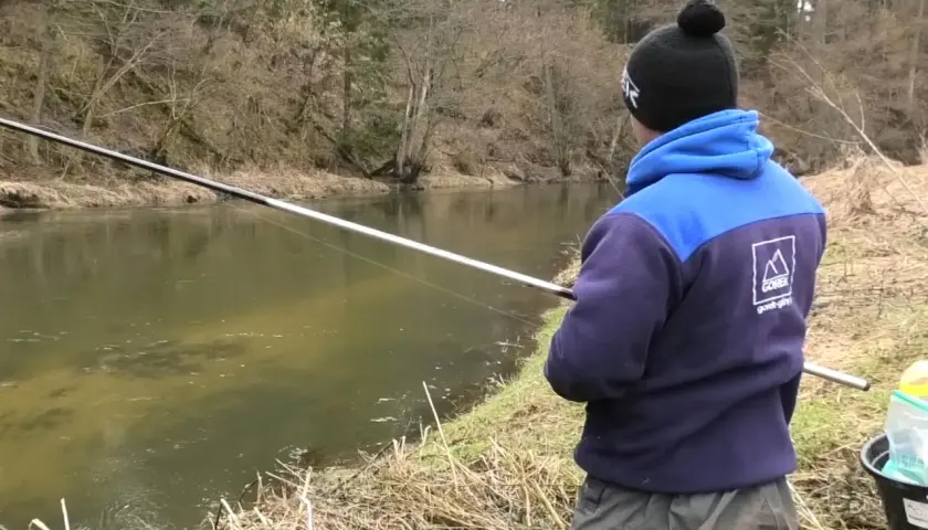 Chłopak łowi ryby na spławik nad rzeką. Pokazuje, jak łowić duże ryby na spławik.
