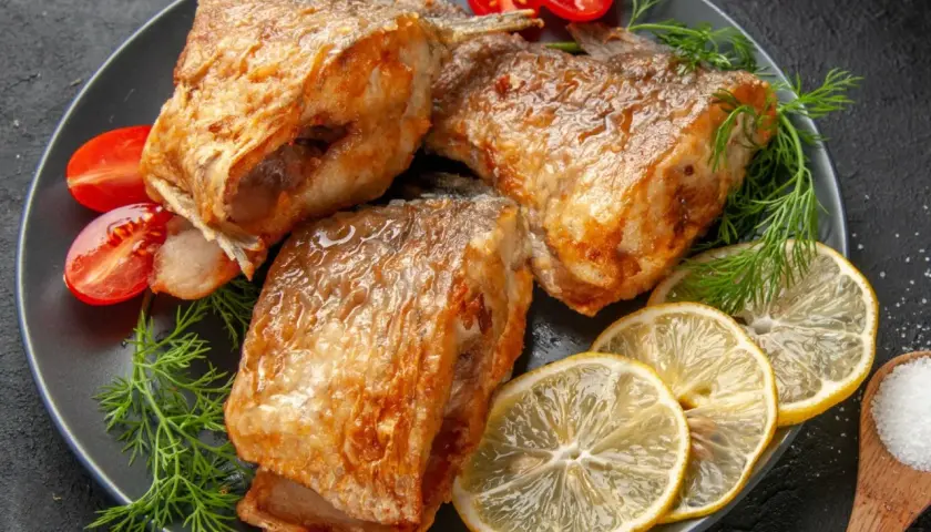 Złocisty karp pieczony, podany z cytryną, pomidorkami i koperkiem. Idealny sposób, jak przyprawić karpia do pieczenia, by był pyszny.