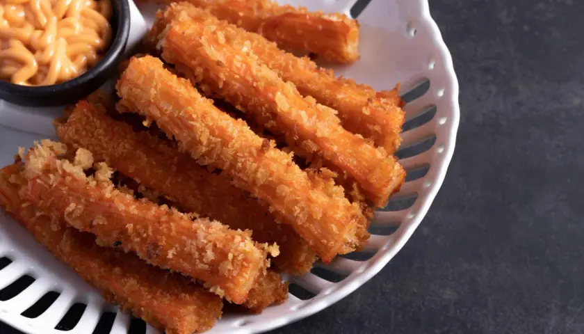 Chrupiące paluszki surimi w panierce, idealne do ciepłych dań. Podane z kremowym sosem.