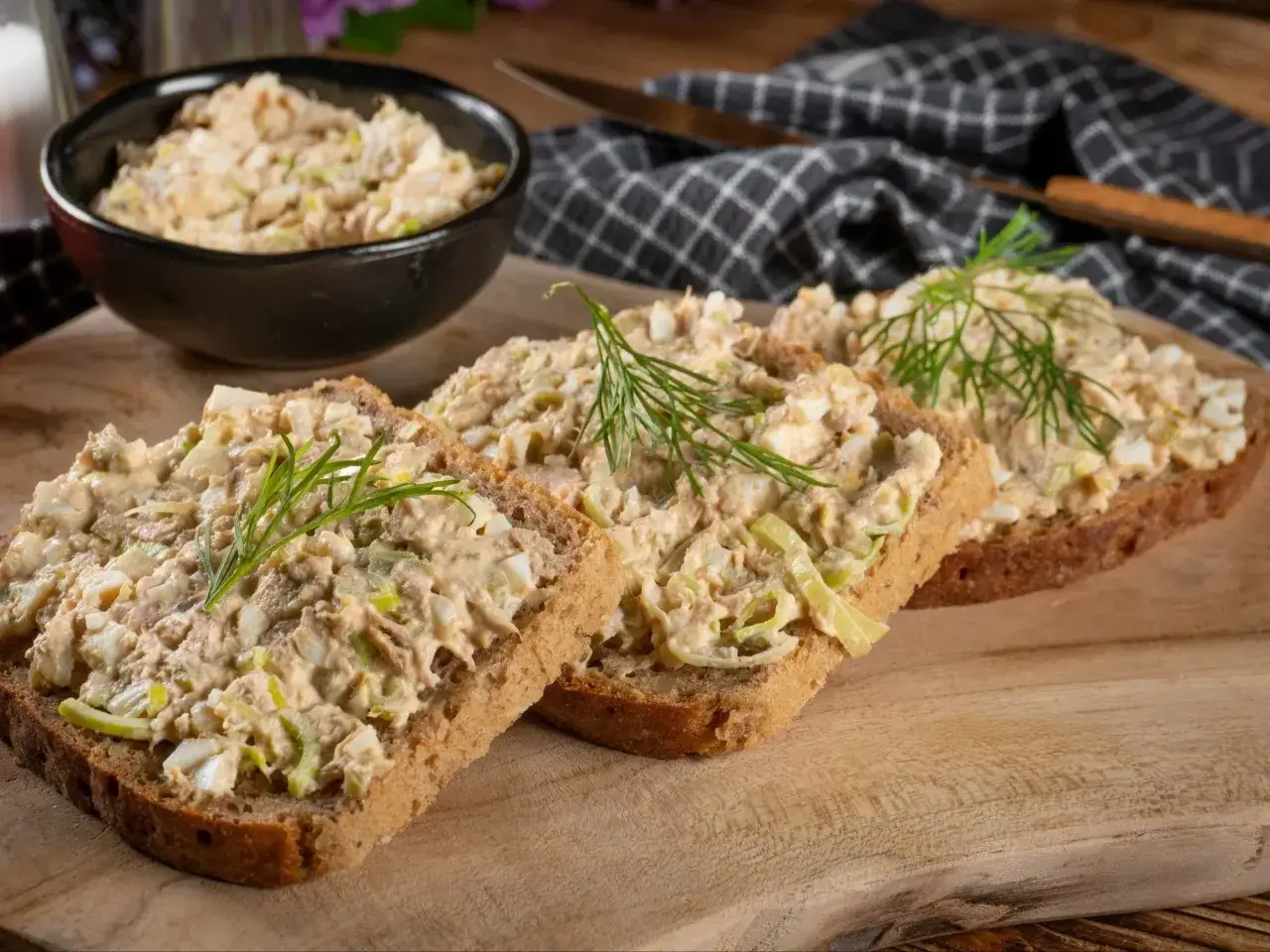 Pyszna pasta rybna na kanapki z jajkiem i koperkiem, podana na ciemnym pieczywie. Idealna na szybkie śniadanie lub przekąskę.